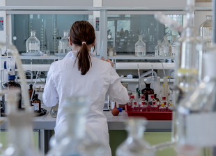 female student in lab with lots of beakers